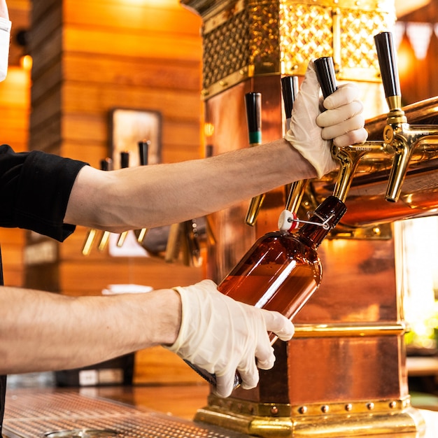 L'uomo versando, riempiendo un bicchiere di birra, boccale