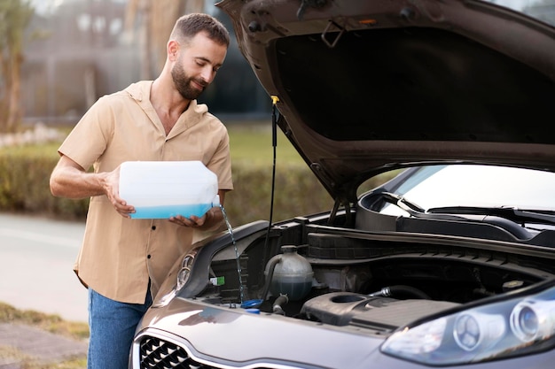 Man pouring windshield washer fluid for clearing car. Car service concept