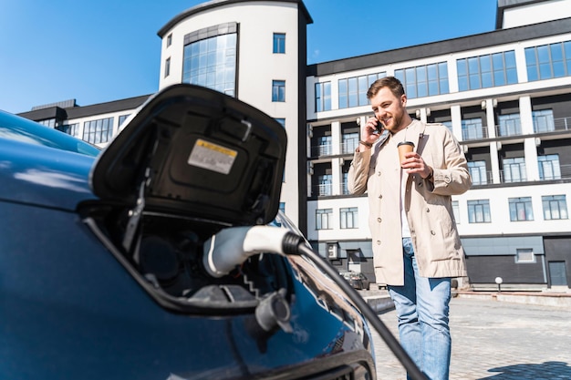 Man praat aan de telefoon en drinkt koffie