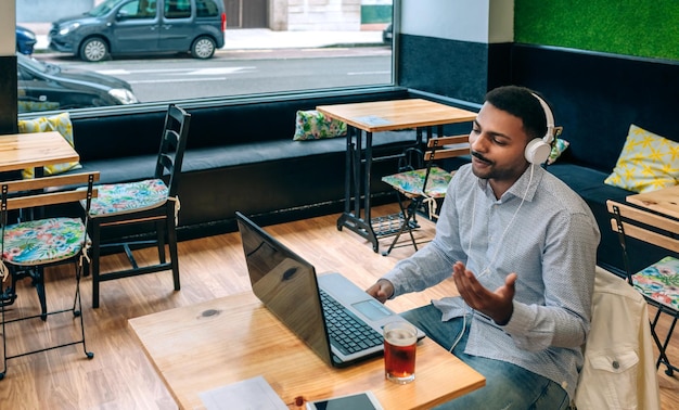 Man praat op videogesprek met laptop uit de koffieshop