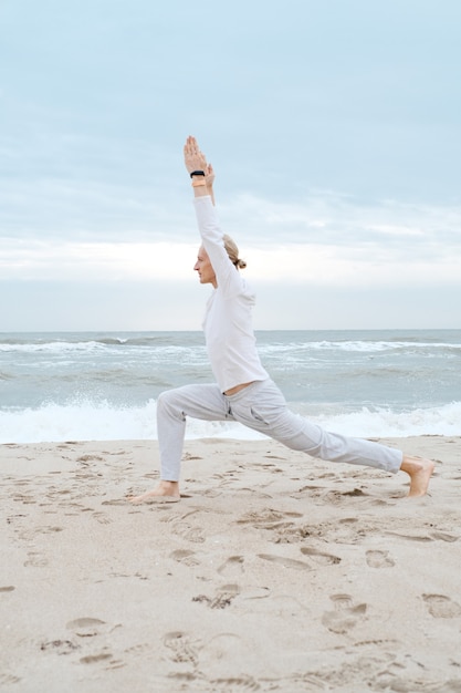 Man practice yoga on sea beach adult practice yoga on the beach