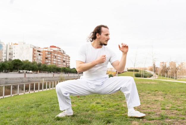 Man practices martial arts in the park in winter