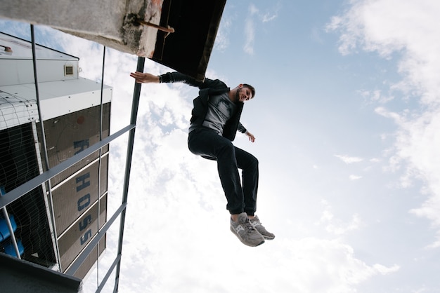 A man practices parkour, runs and jumps over obstacles