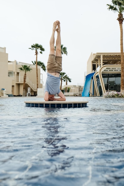 Man practicing yoga by the water