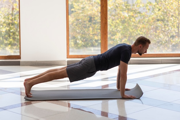 Uomo che pratica yoga all'interno