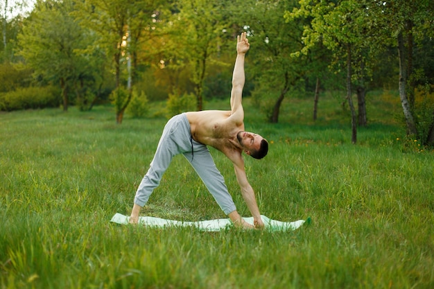 Man practicing yoga in the park