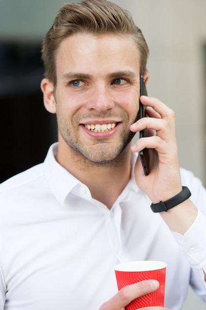 Man praten op mobiele telefoon met koffiekopje. gelukkig zakenman. verbonden blijven. koffiepauze.