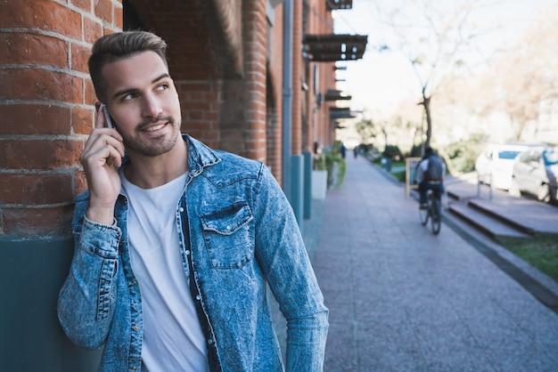 Man praten over de telefoon buitenshuis.