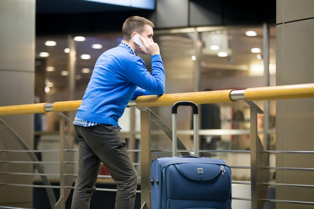 Man praten over de telefoon leunend op een balustrade