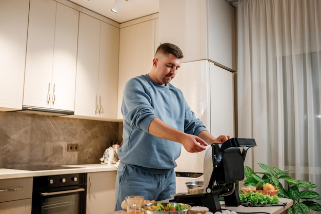 Man prepares delicious juicy meat steak on an electric grill on wooden table Smoke in the home kitchen