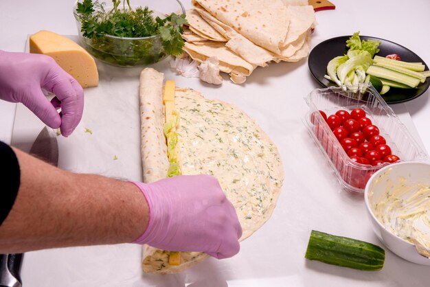 A man prepares diet pita rolls close-up copy space template