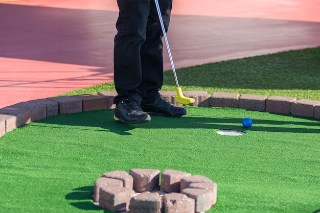 A man prepares to hit a ball during mini golf game