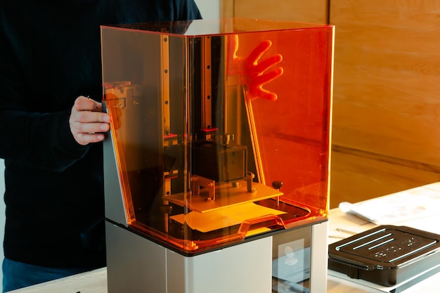 Photo man preparing a 3d resin printer before use