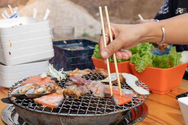 Foto uomo che prepara il cibo su una griglia da barbecue