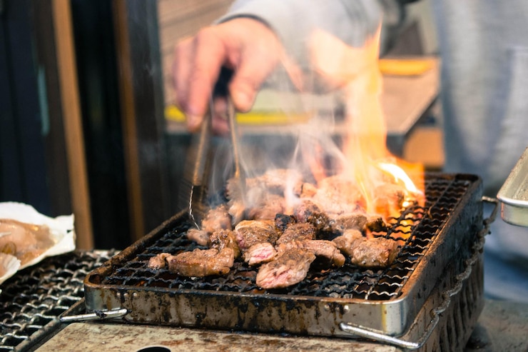Photo バーベキューのグリルで食べ物を準備している男性