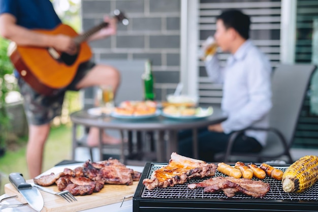 写真 バーベキューグリルで料理を準備している男