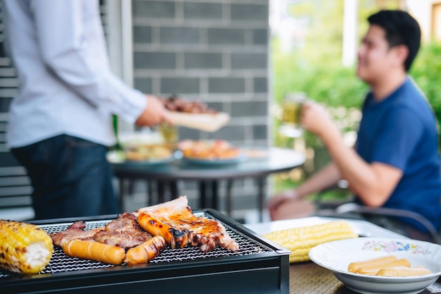 写真 バーベキューのグリルで食べ物を準備している男性