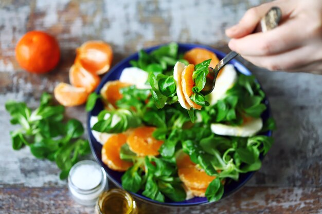 Man preparing fresh salad on a plate