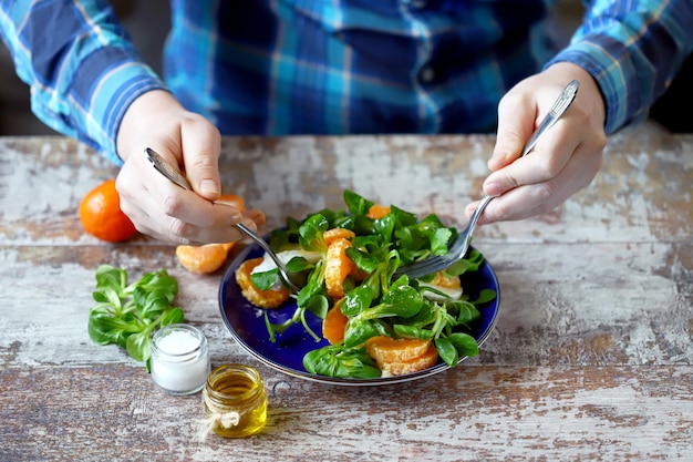 Man preparing fresh salad on a plate