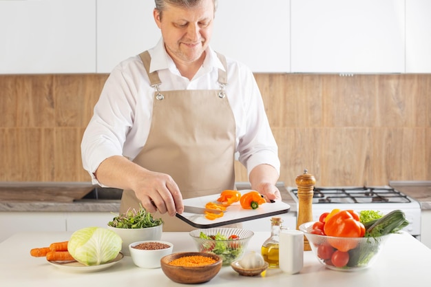 Man preparing healthy vegetarian food  on  table in  kitchen