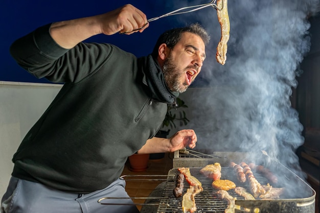 Man preparing meat on barbecue grill at terrace