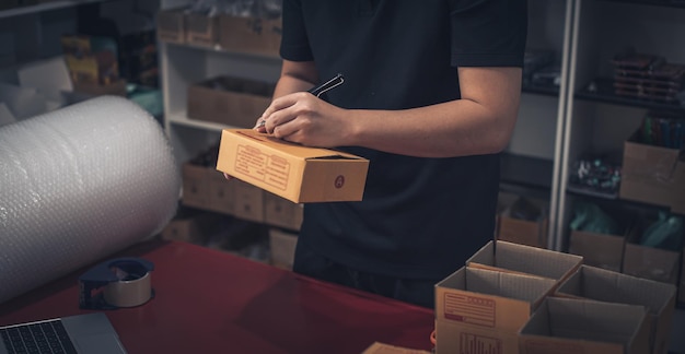 man preparing a parcel for delivery at online selling business office Ecommerce drop shipping