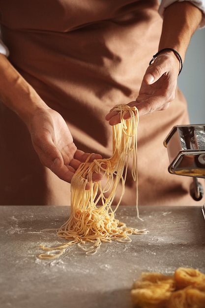 Man preparing pasta in kitchen close up view