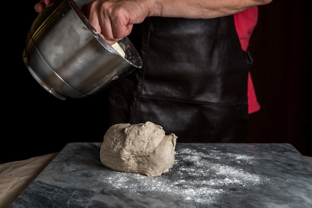 Man preparing pizza dough on marble table