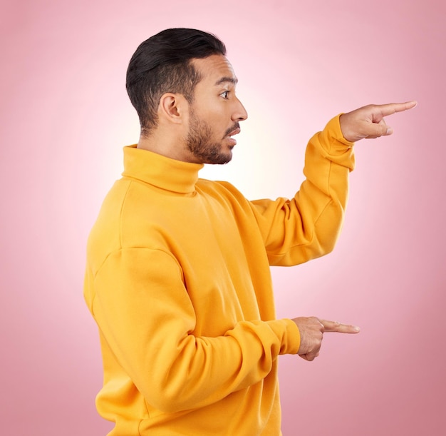 Man presentation and pointing to surprise information and announcement list and university schedule Steps advice and shocked student or young person with hand guide on a studio pink background