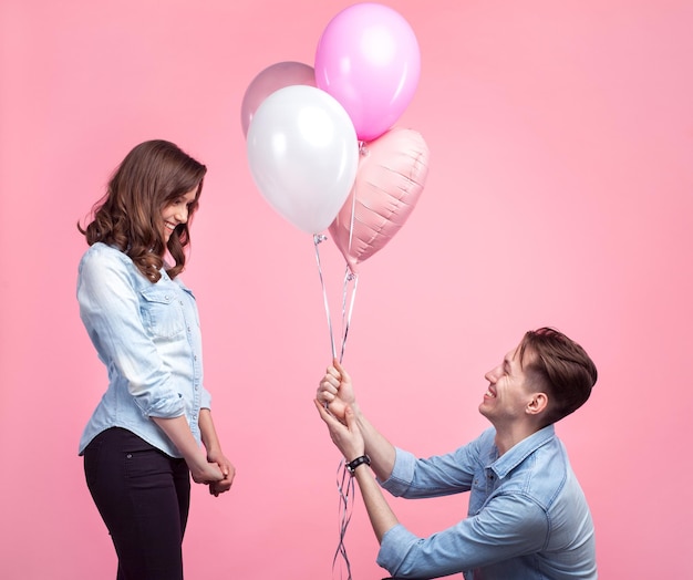 Man presenting balloons to girl