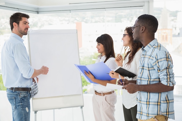 Man presenting and coworkers taking notes