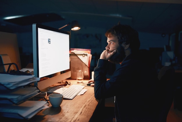 man programmer and night with computer thinking and stress for glitch screen and coding error person developer and pc with monitor reading and information technology with problem solving on web