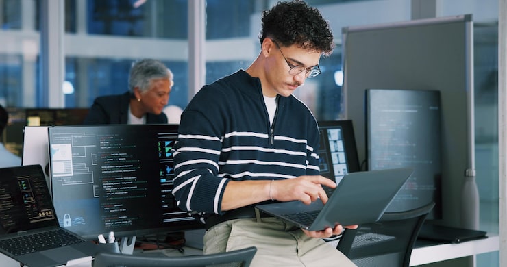 Photo man programmer and office with laptop for coding software development or app design male person coder or developer with computer or technology for cybersecurity web or it services at workplace