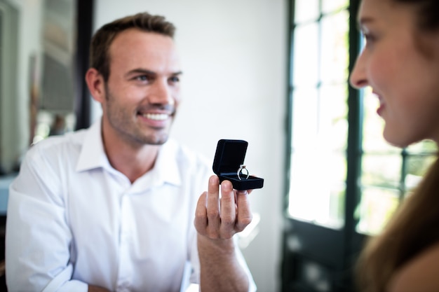 Man proposing to woman offering engagement ring