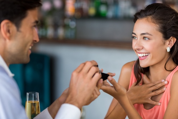 Man proposing to woman offering engagement ring