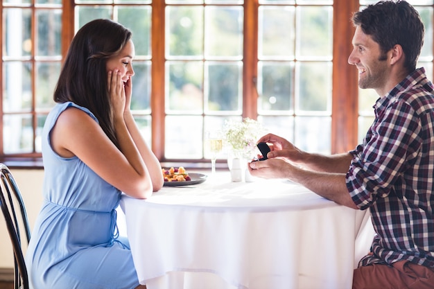 Мужчина предлагает женщине в ресторане