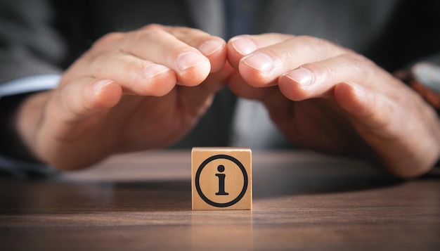 Foto l'uomo protegge il simbolo delle informazioni sul cubo di legno