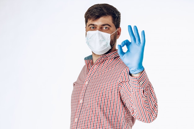 Man protecting from the coronavirus with a mask and gloves showing ok sign