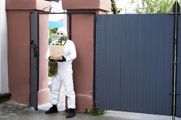 A man in protective clothing and a gas mask brought food