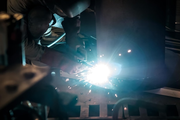 Man in protective gloves cutting metal using angle grinder making sparks