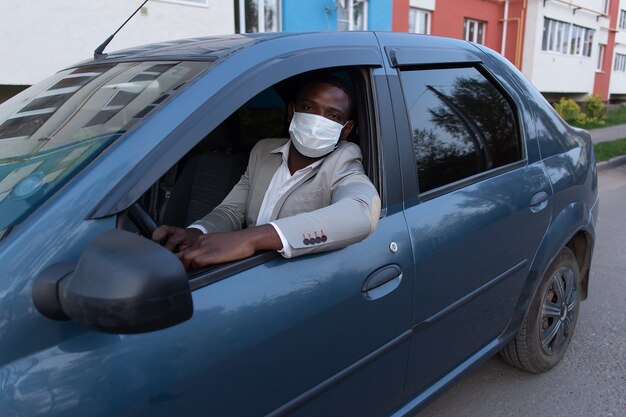 Man in protective mask in car