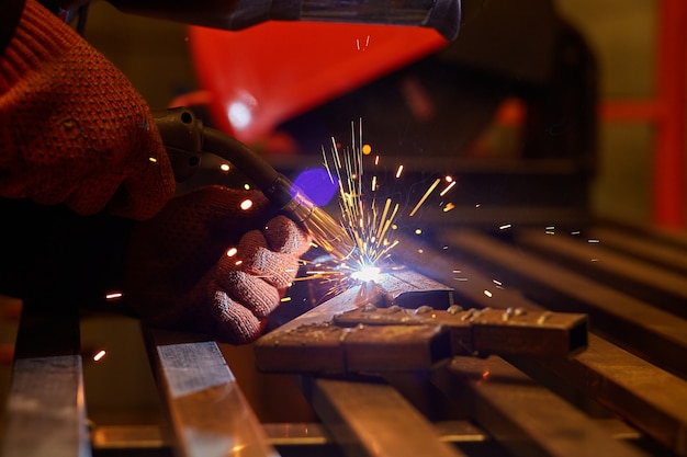 A man in a protective mask carries out welding work in the\
garage.