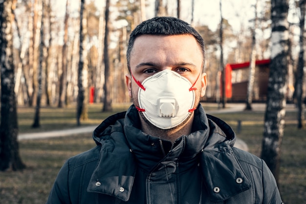 Photo a man in a protective mask in an empty park.  coronavirus pandemic.