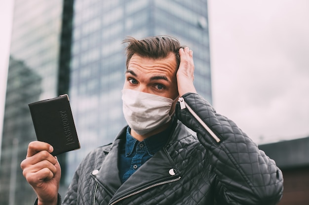 man in a protective mask with a personal passport.