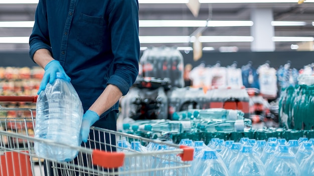 Man in a protective mask with a shopping cart standing in the trading floor. photo with a copy-space