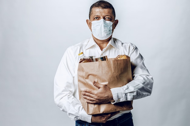 Man in a protective medical mask with a bag from a grocery store