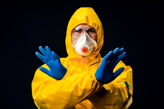 A man in a protective suit on a black background. Protection against virus outbreaks.