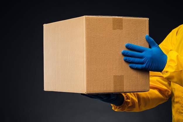 A man in a protective suit and mask delivers an antiviral vaccine to the population. Shipping during the quarantine.