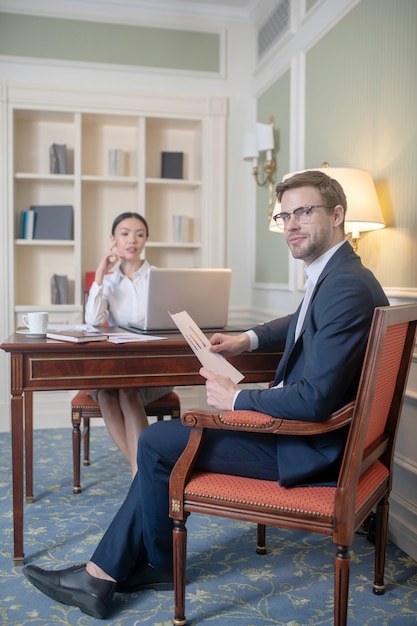 A man providing his female boss with a report