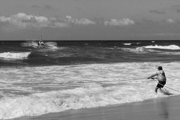 Man pulling rope on beach